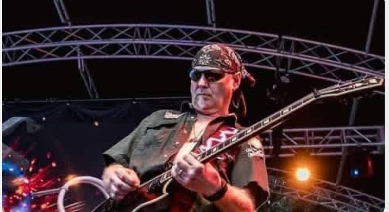 Chris Archis playing guitar on stage