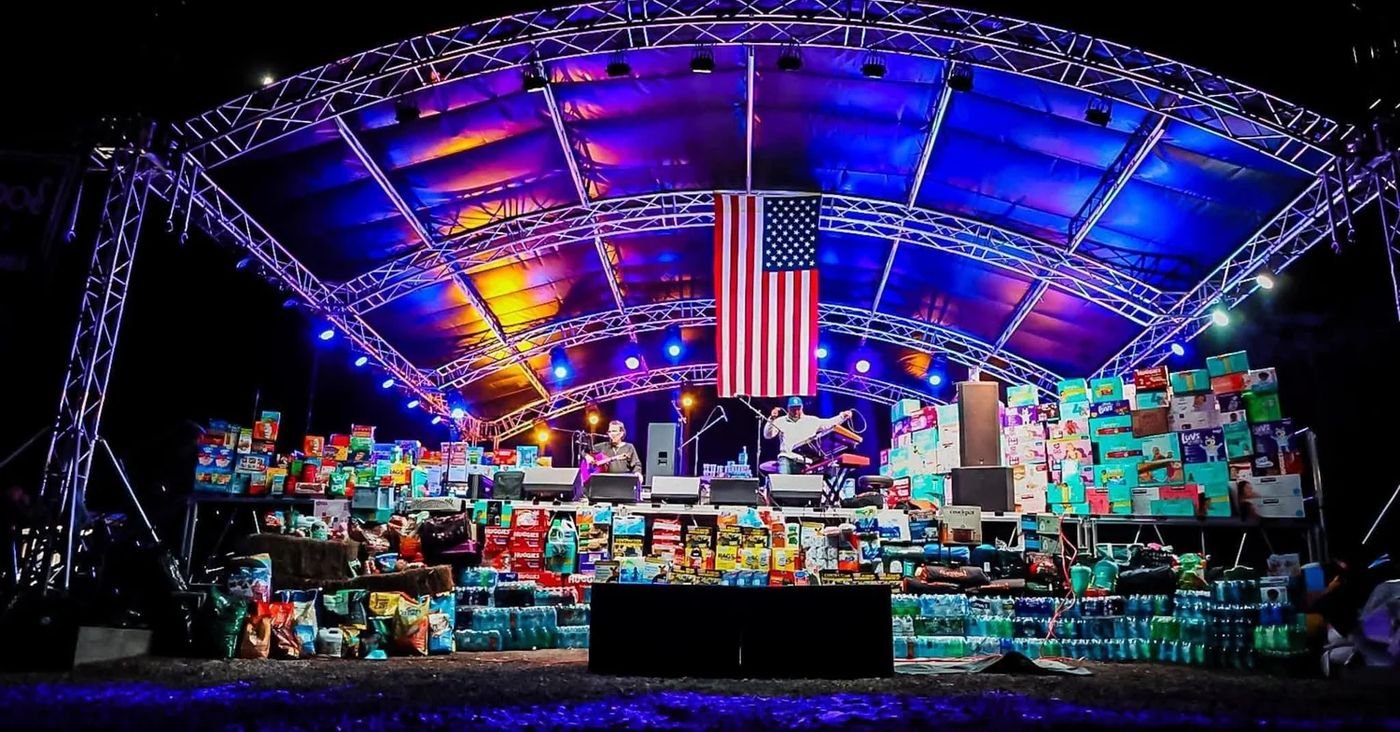 Relief supplies stacked wall to wall under an American flag after Hurricane Helene